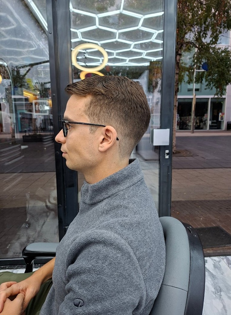 Klant met bril en een korte, nette knipbeurt met fade