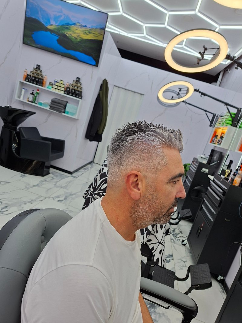 Klant met grijs haar, kort geknipt en omhoog gestyled, in de salon